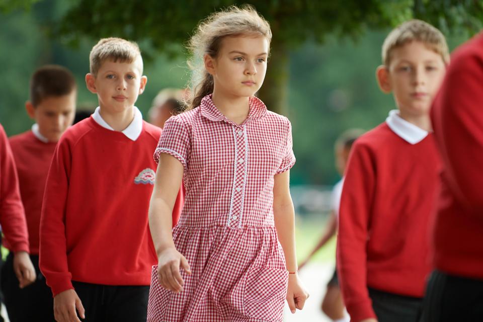 Pupils walking into school from the field