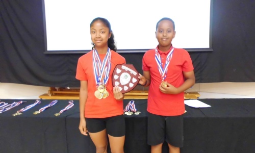 Two children holding up sports trophy